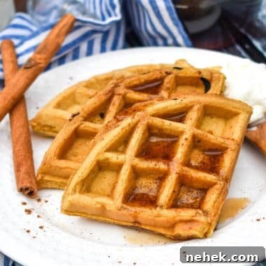 pumpkin spice waffles topped with syrup on a white plate