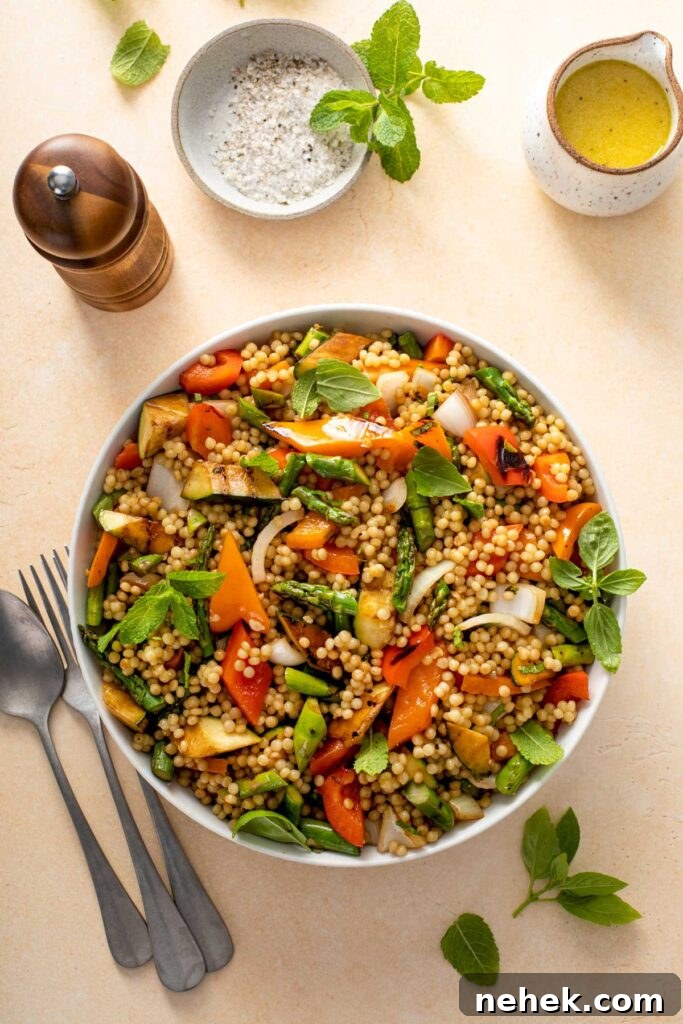 Top view of a bowl filled with cooked pearl couscous and grilled vegetables