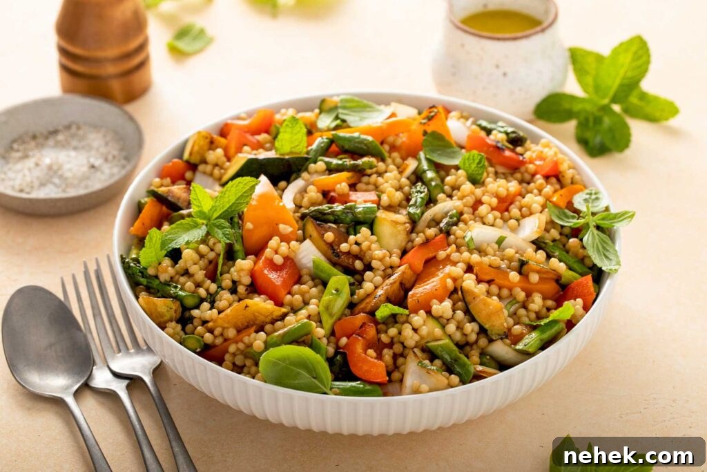 a bowl filled with cooked pearl couscous and grilled vegetables
