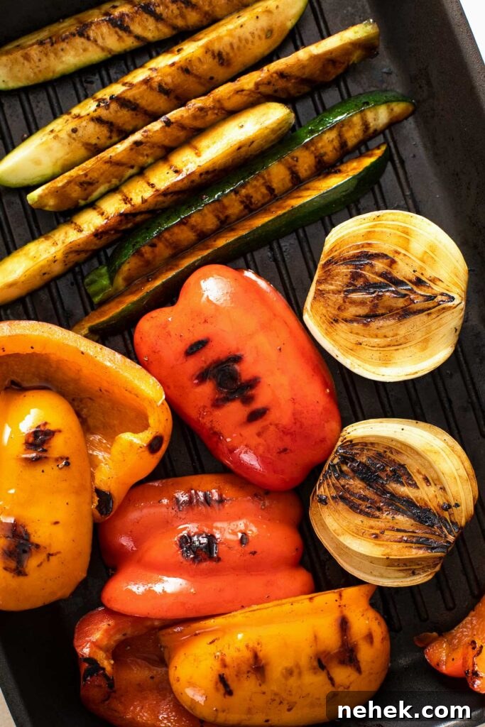 Caramelized and grilled marked grilled bell peppers, onions, zucchini and yellow squash on a grill pan