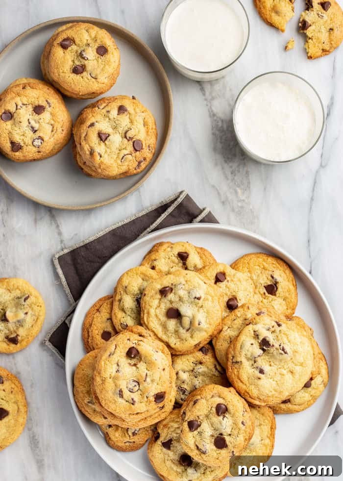 Chocolate Chip Pudding Cookies Recipe — Soft, Chewy Treats 2 Plates filled with chocolate chip pudding cookies next to glasses of milk