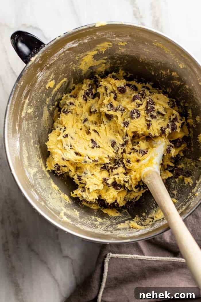 Chocolate Chip Pudding Cookies Recipe — Soft, Chewy Treats 7 Spatula in a metal bowl filled with chocolate chip pudding cookie dough