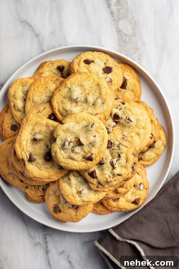Chocolate Chip Pudding Cookies Recipe — Soft, Chewy Treats 10 White platter filled with chocolate chip pudding cookies, set on a marble countertop