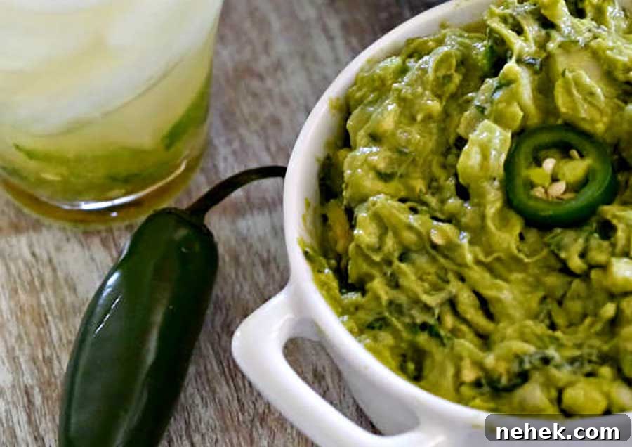 guacamole in a bowl with jalapenos