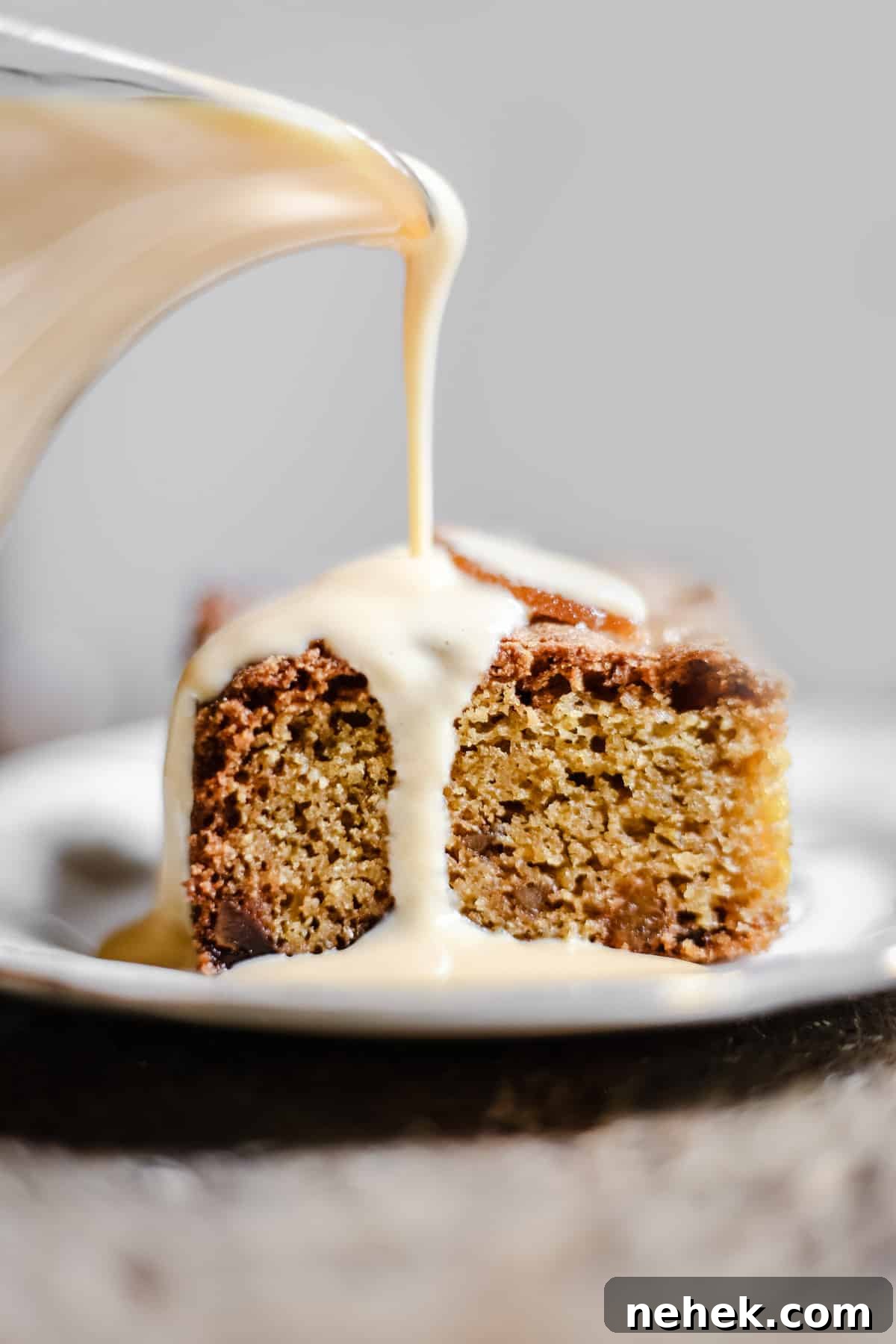 Lemon and Ginger Cake on a plate being drizzled with lemon custard