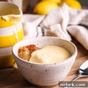 Lemon custard poured over lemon sponge pudding in a bowl.