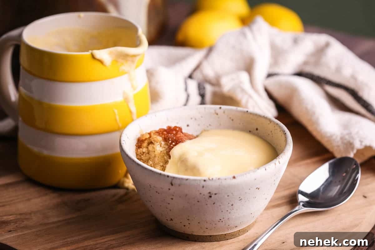 Lemon custard poured over lemon sponge pudding in a bowl.