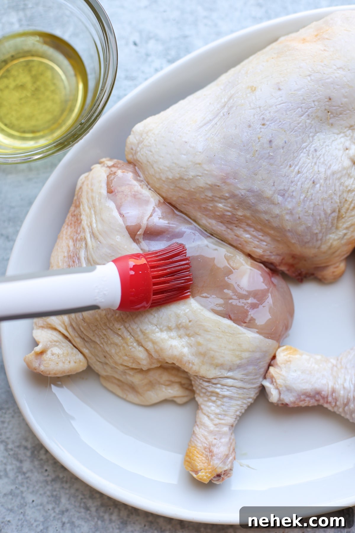 How to Smoke Chicken Leg Quarters for Juicy, Flavorful Results 4 Person basting on olive oil to raw chicken quarters.