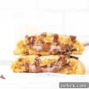 Single serving chocolate chip cookie stuffed with Nutella, broken in half with cookie halves placed on top of each other