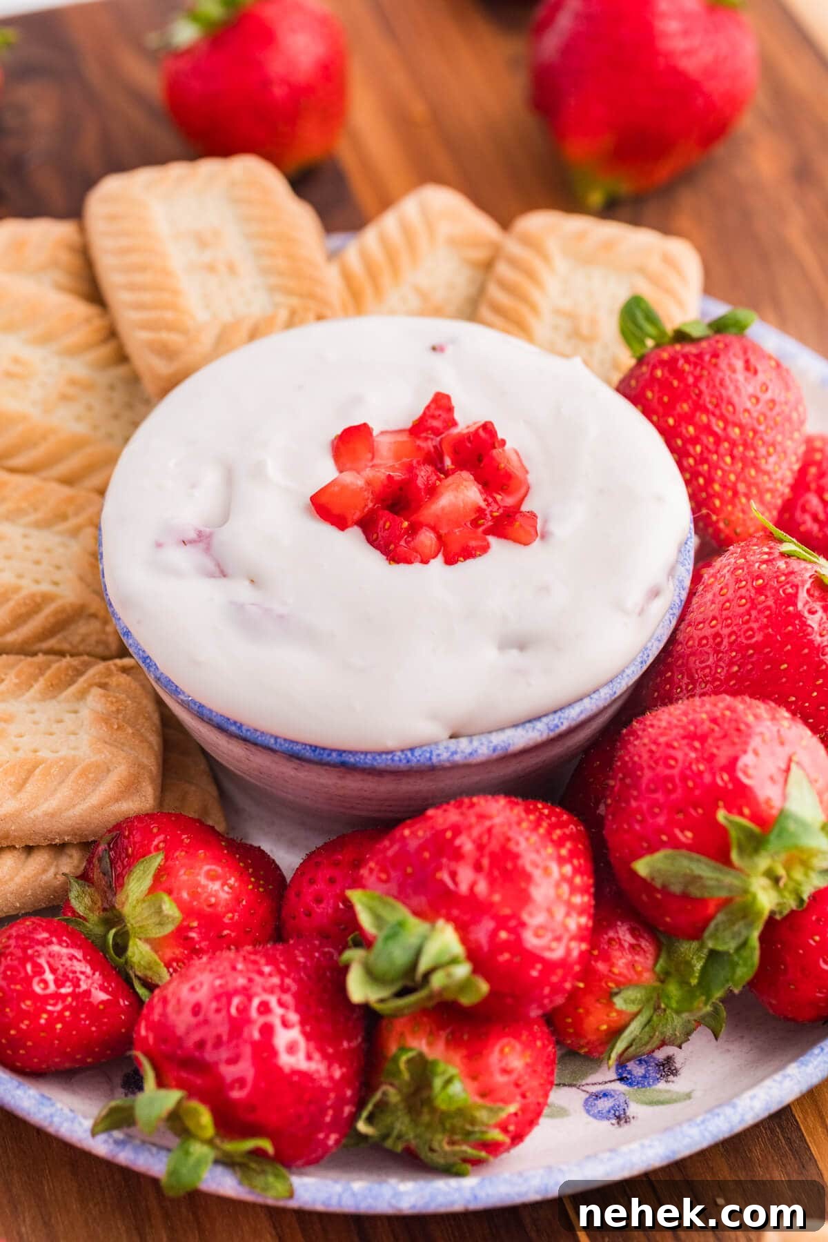 Creamy Strawberry Cheesecake Dip Recipe for Parties 2 Strawberry cheesecake dip surrounded by cookies and strawberries.