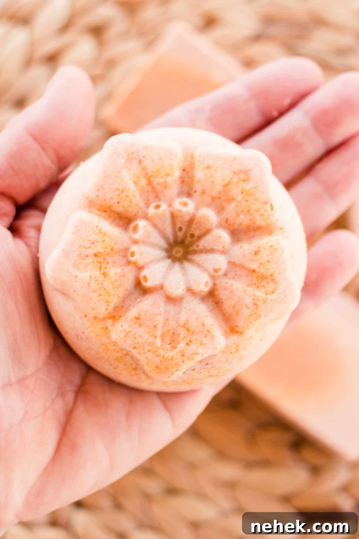 Homemade Turmeric Soap Recipe for Glowing Skin 13 Holding a bar of flower-shaped soap.