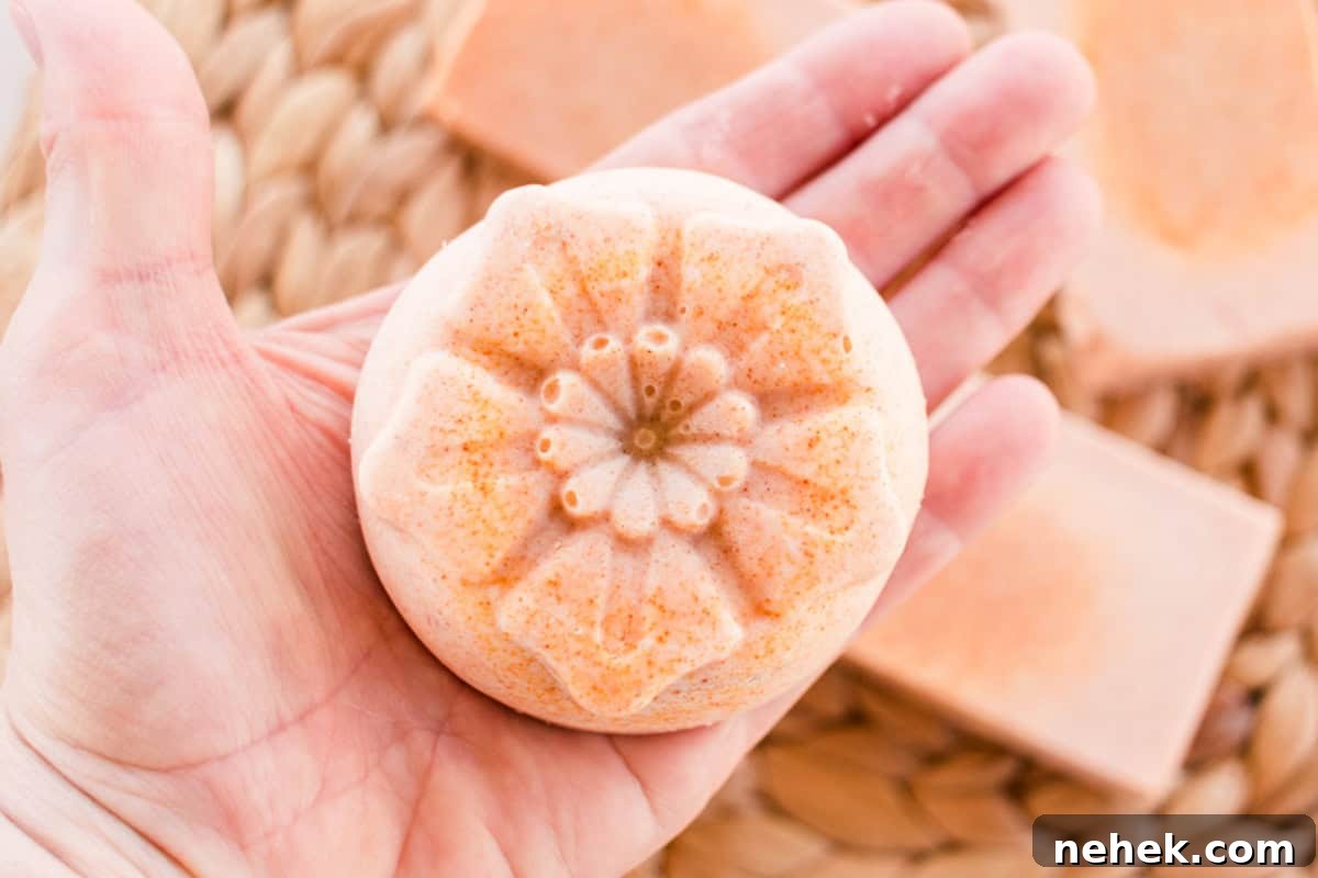 Homemade Turmeric Soap Recipe for Glowing Skin 3 Holding a flower-shaped bar of orange soap in the palm of a hand.