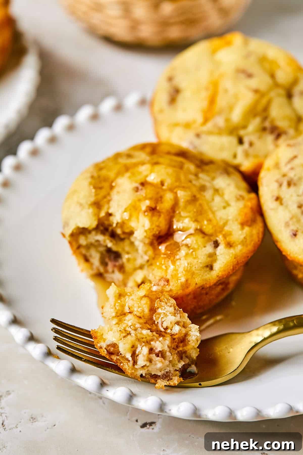 Overhead view of golden McGriddle muffins in muffin tin with maple syrup drizzle