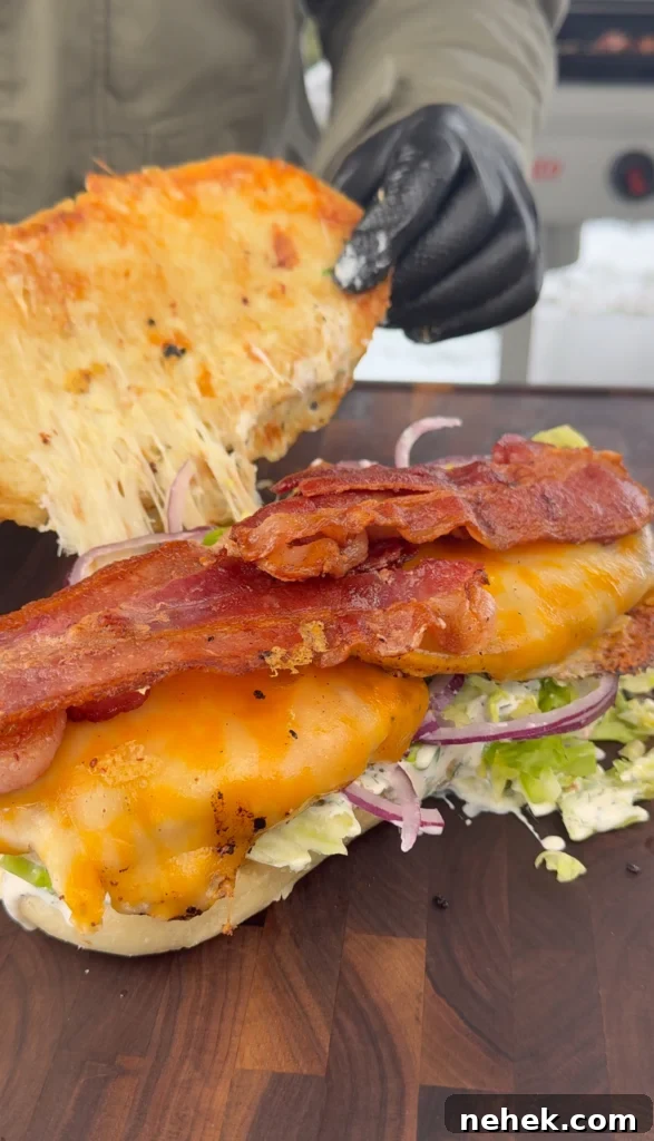 Brioche sandwich roll loaded with grilled chicken, crispy bacon, and fresh toppings, ready to serve.