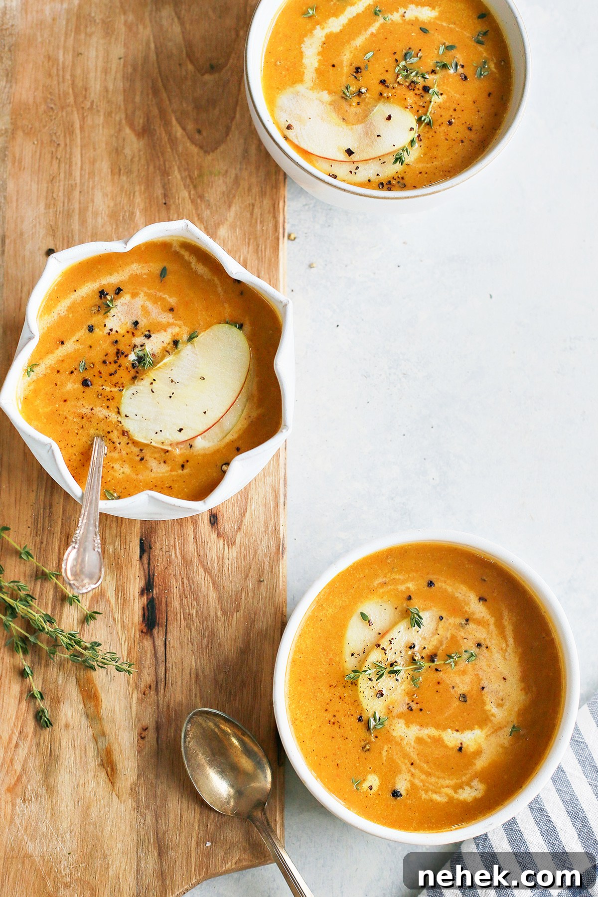 overhead photo of three bowls of butternut squash apple soup