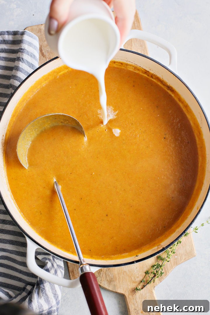 woman pouring cream into butternut squash and apple soup