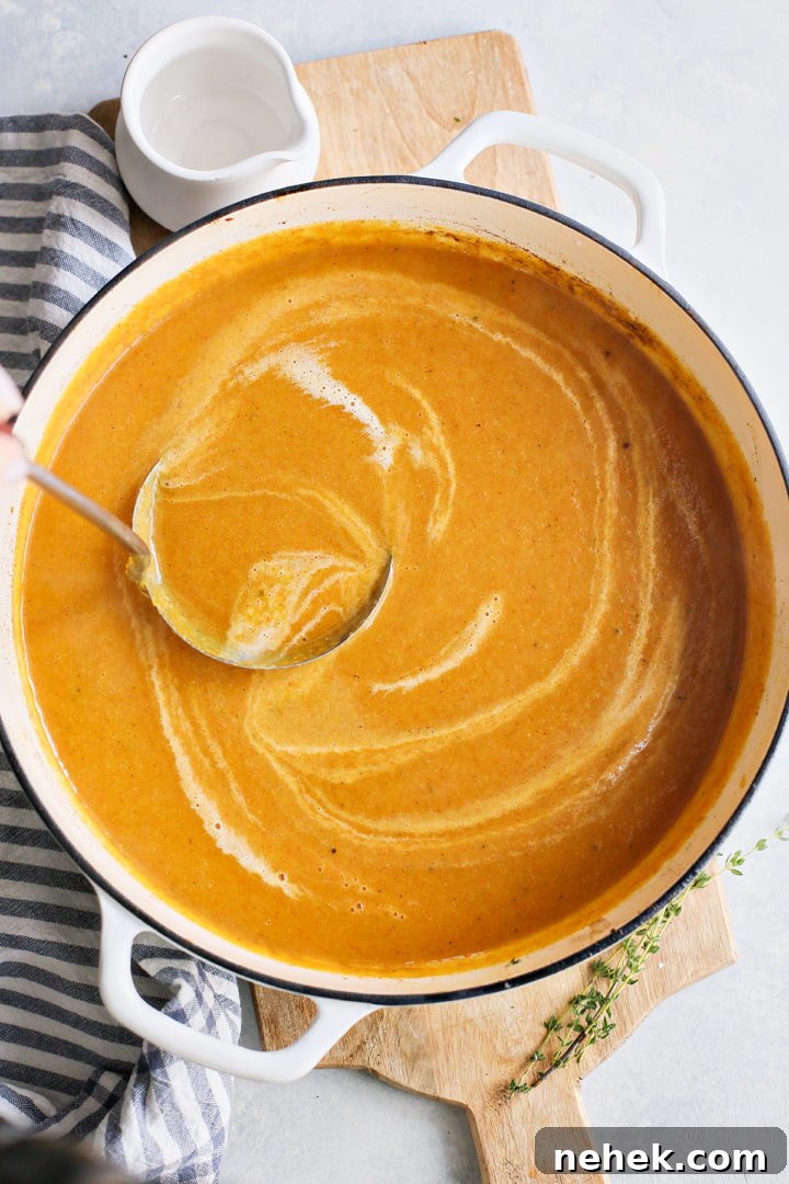 woman stirring a pot of butternut squash and apple soup
