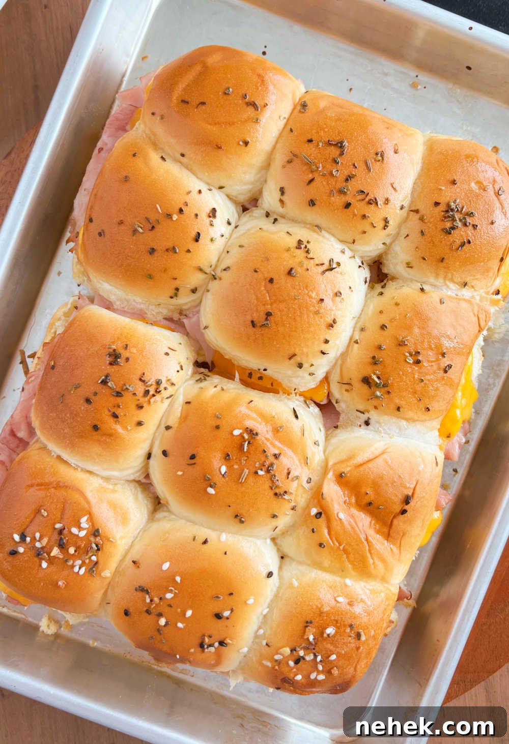 baked ham and cheese sliders made with leftover holiday ham on a baking sheet
