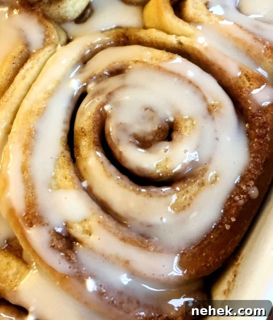 Cooked cinnamon roll topped with a confectioners sugar icing.
