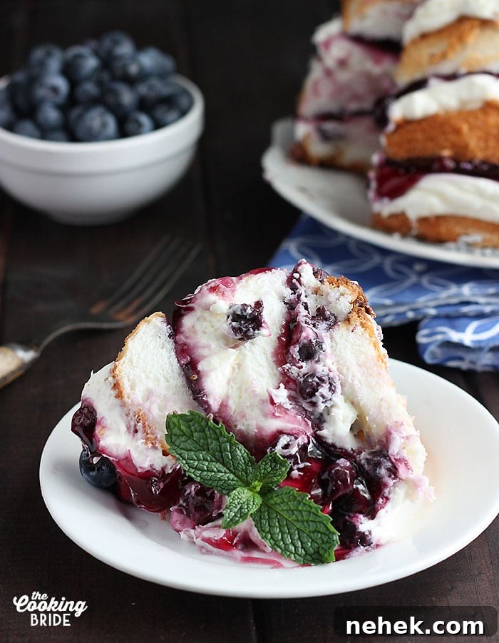 No-Bake Blueberry Icebox Cake Recipe for Summer Desserts 7 slice of blueberry icebox cake with a sprig of mint on a white plate