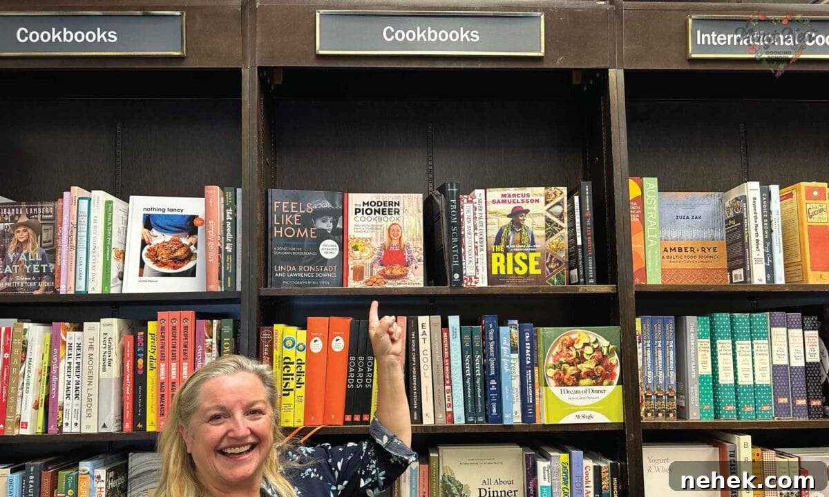 Mary pointing at her cookbook on the shelves at Barnes and Noble.
