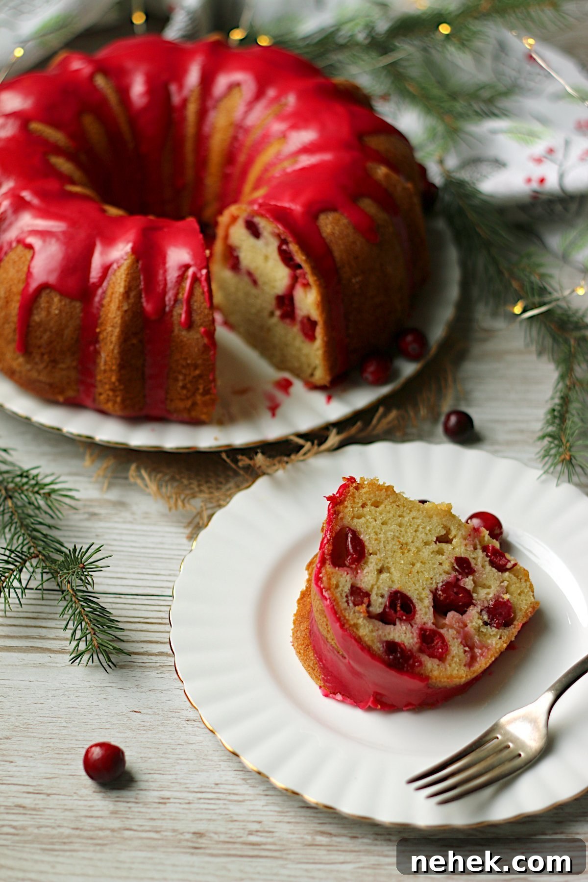 Cranberry Orange Scones with White Chocolate Drizzle 6 A slice of Cranberry Orange Bundt Cake on a small white plate.