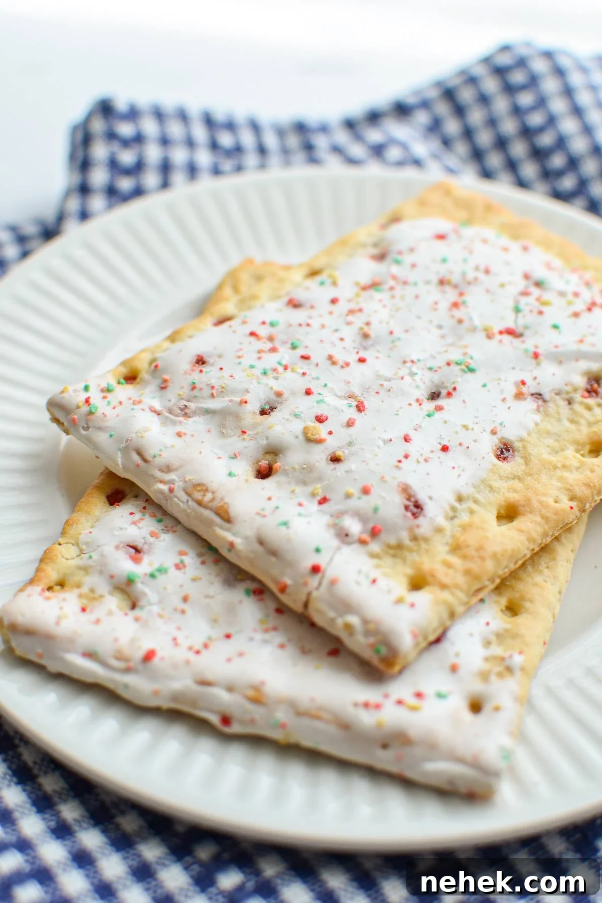 A plate with two strawberry pop tarts layered on top.