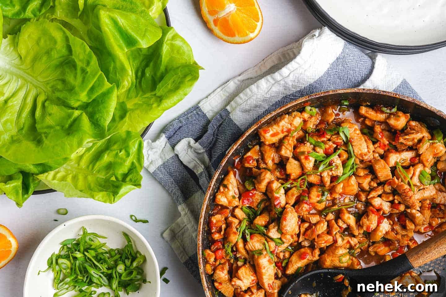 Teriyaki Chicken Lettuce Wraps Recipe for Quick Weeknight Meals 3 Teriyaki Chicken in pan with lettuce oranges and green onion on the side