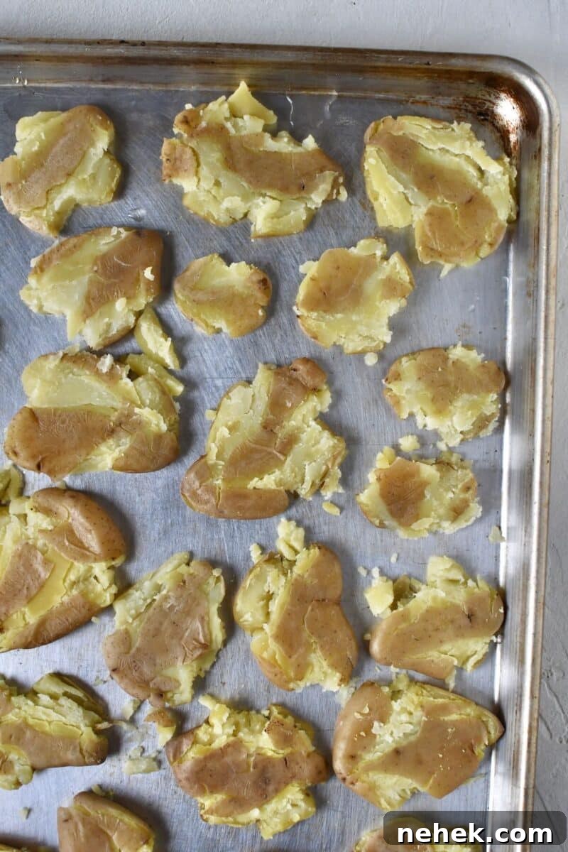 Crispy Smashed Potatoes with Garlic and Herbs 7 All potatoes smashed on a rimmed baking sheet.