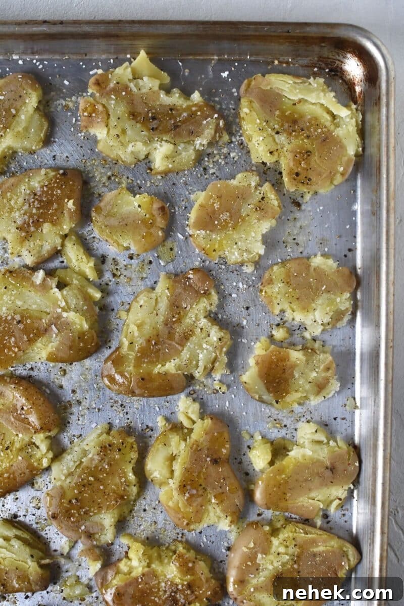 Crispy Smashed Potatoes with Garlic and Herbs 8 All potatoes smashed and seasoned with salt, pepper, butter, and oil on a rimmed baking sheet.