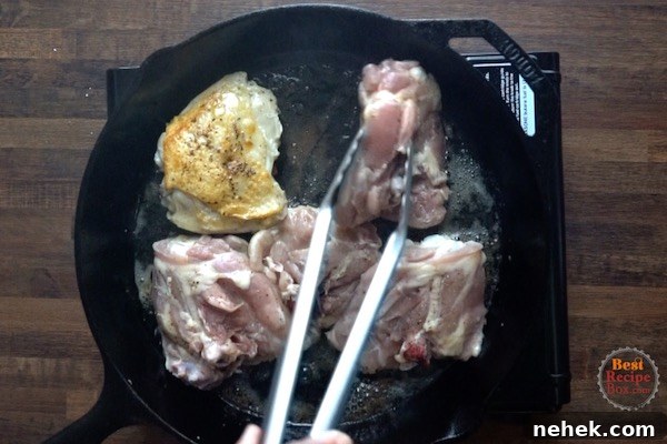 Searing the skin side of the chicken thighs