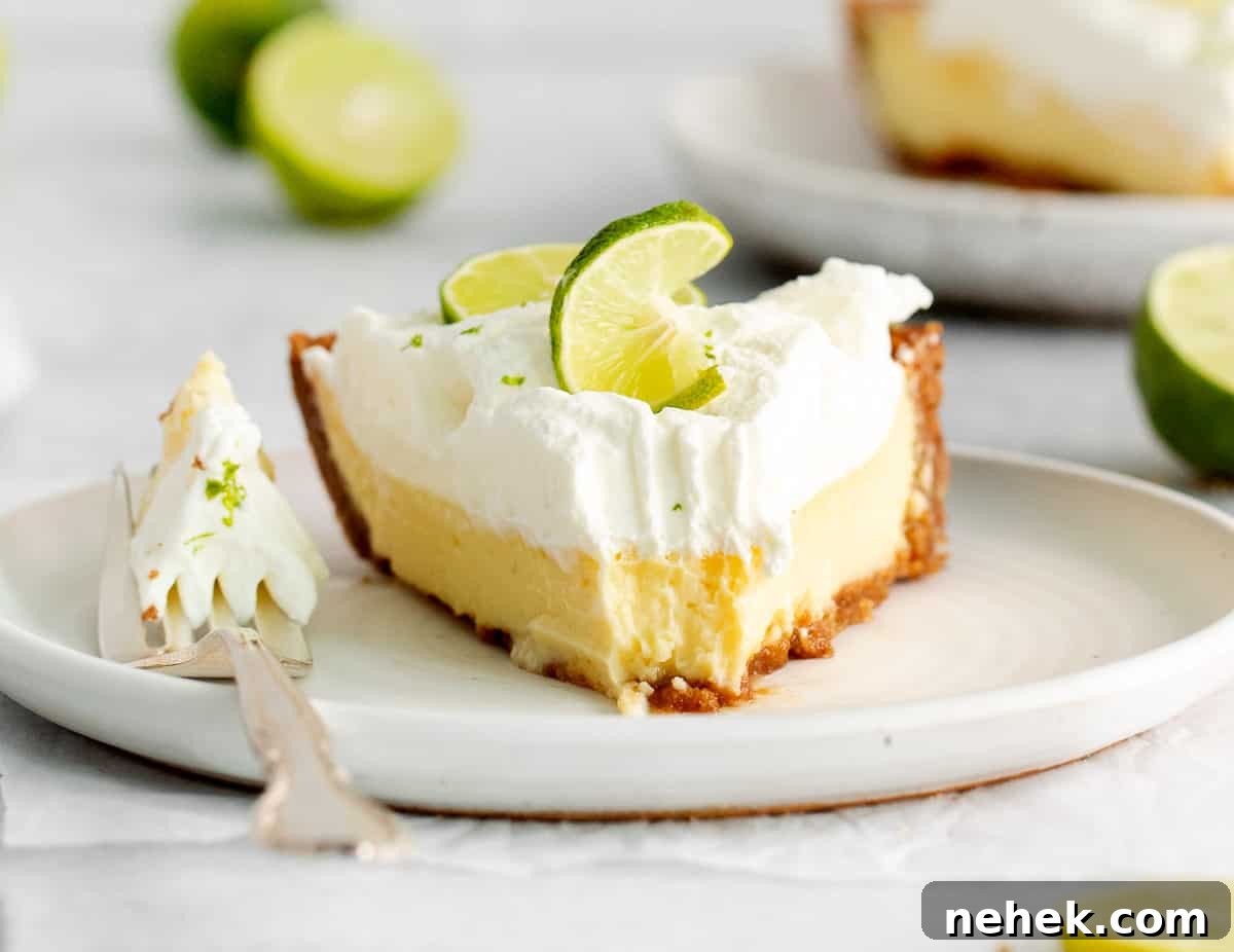 A slice of key lime pie on a plate with a bite on the fork.