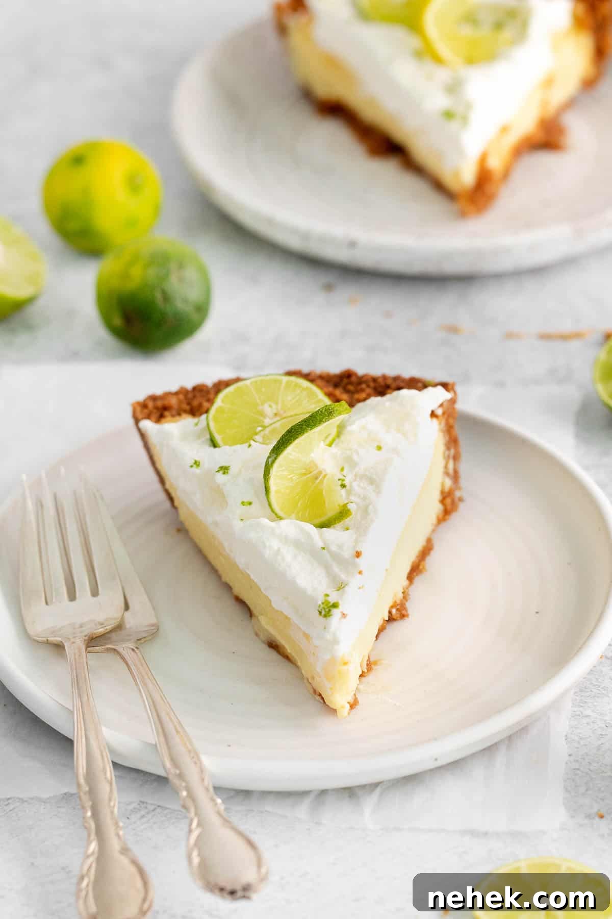A slice of key lime pie on a plate with forks.