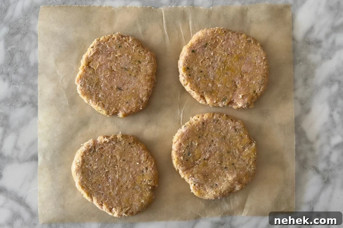 Chicken Parmesan Burger Recipe: Crispy, Cheesy Sandwiches 5 Chicken parmesan patties on parchment paper.