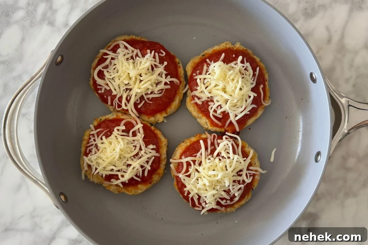 Chicken Parmesan Burger Recipe: Crispy, Cheesy Sandwiches 7 Chicken patties topped with marinara and cheese.