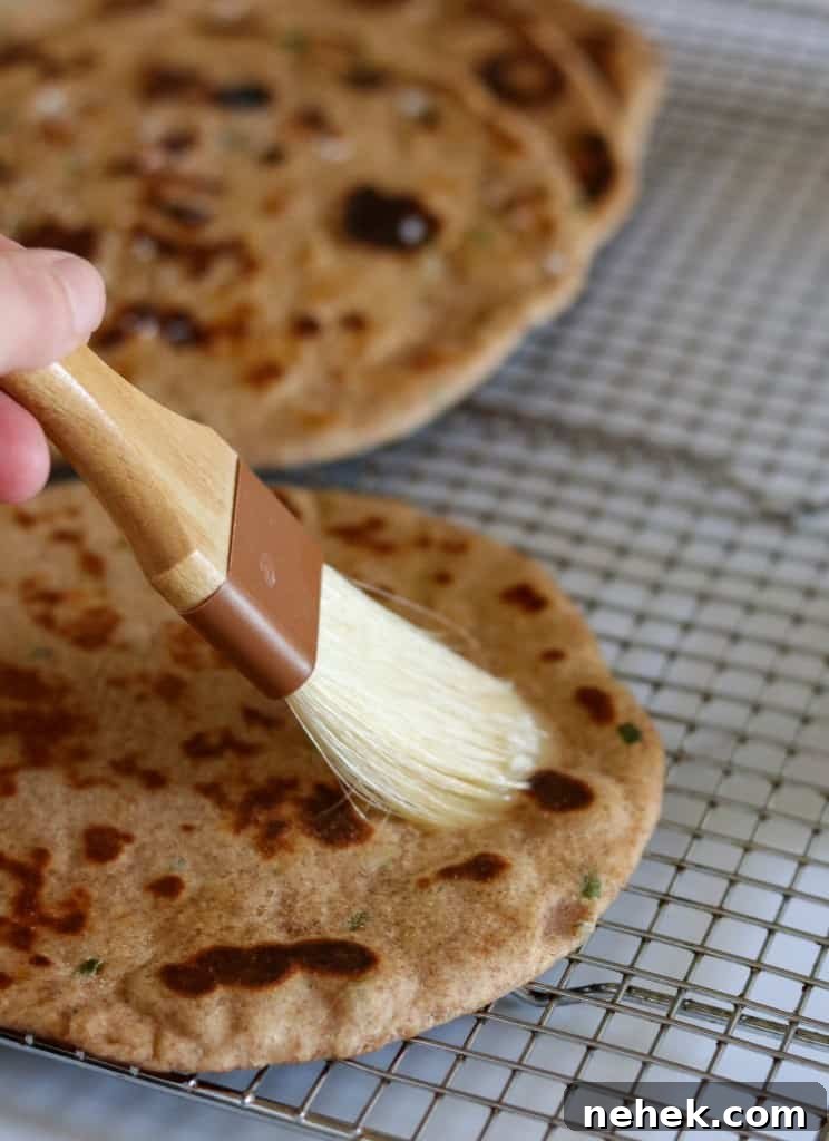 Person brushing a flatbread with butter