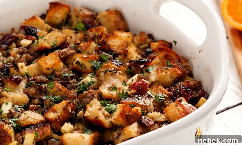 a casserole dish with sausage, cranberry, and apple stuffing in it. 