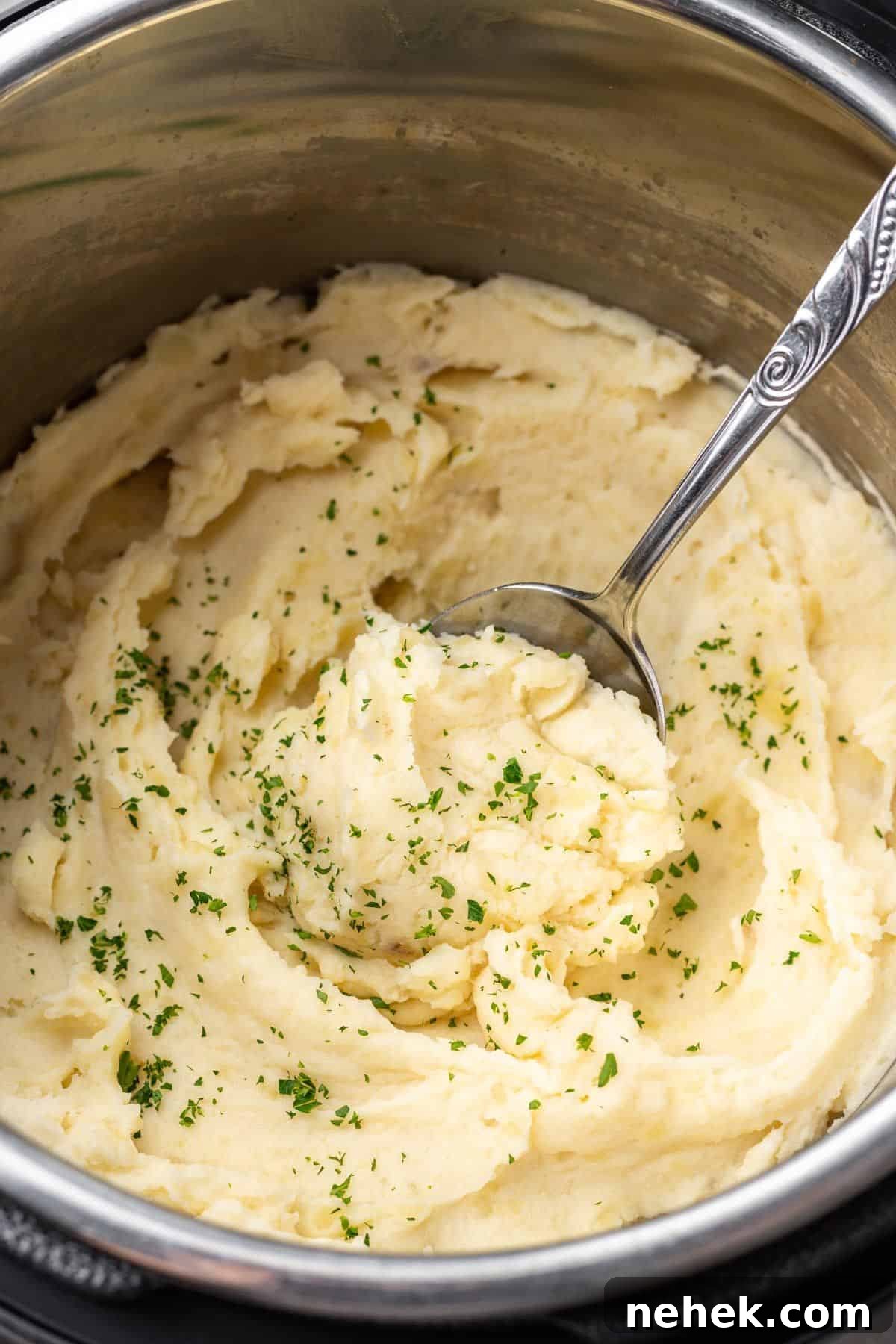 an instant pot filled with mashed potatoes and minced parsley. 