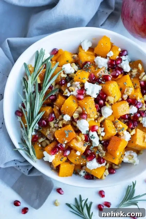 a bowl of roasted butternut squash with goat cheese, walnuts, and pomegranate seeds. 