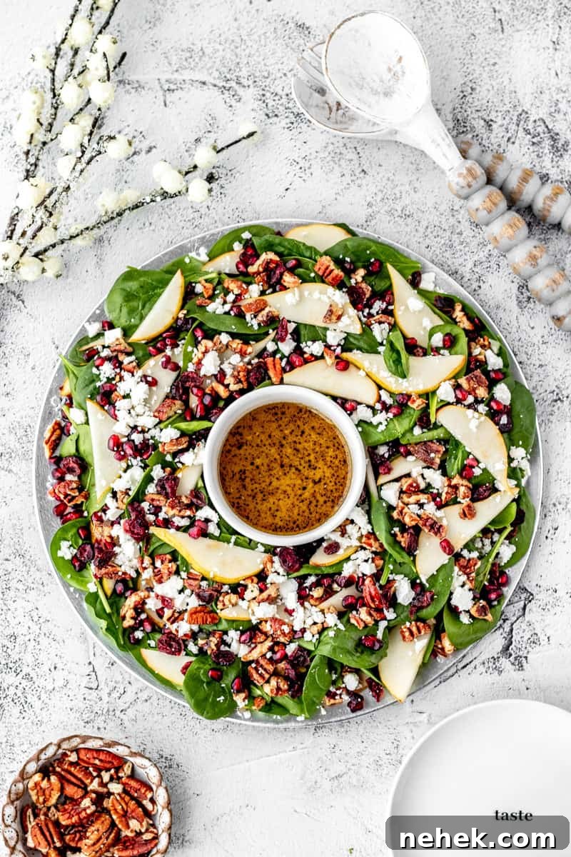 a spinach salad wreath with pear, pomegranate, and feta. 