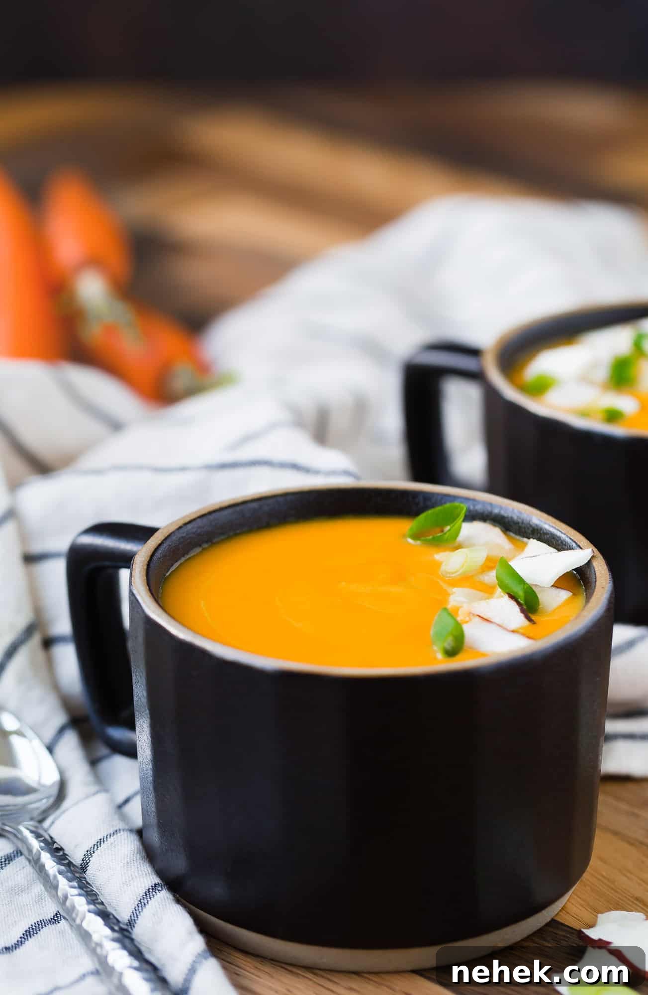 Vibrant Carrot Ginger Soup — Vegan & Whole30-Friendly Recipe 4 Soup in a black mug style bowl.