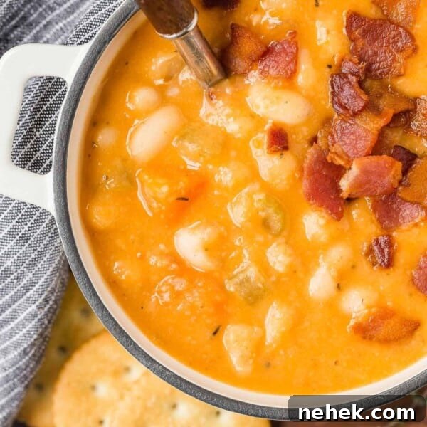 Bean soup topped with bacon in a small white bowl.
