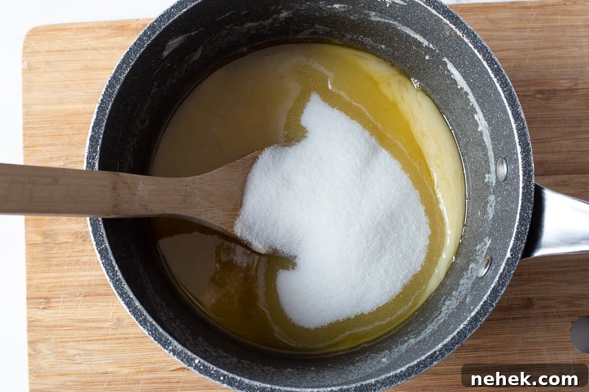 Sugar is added to butter and chocolate mixture in saucepan.