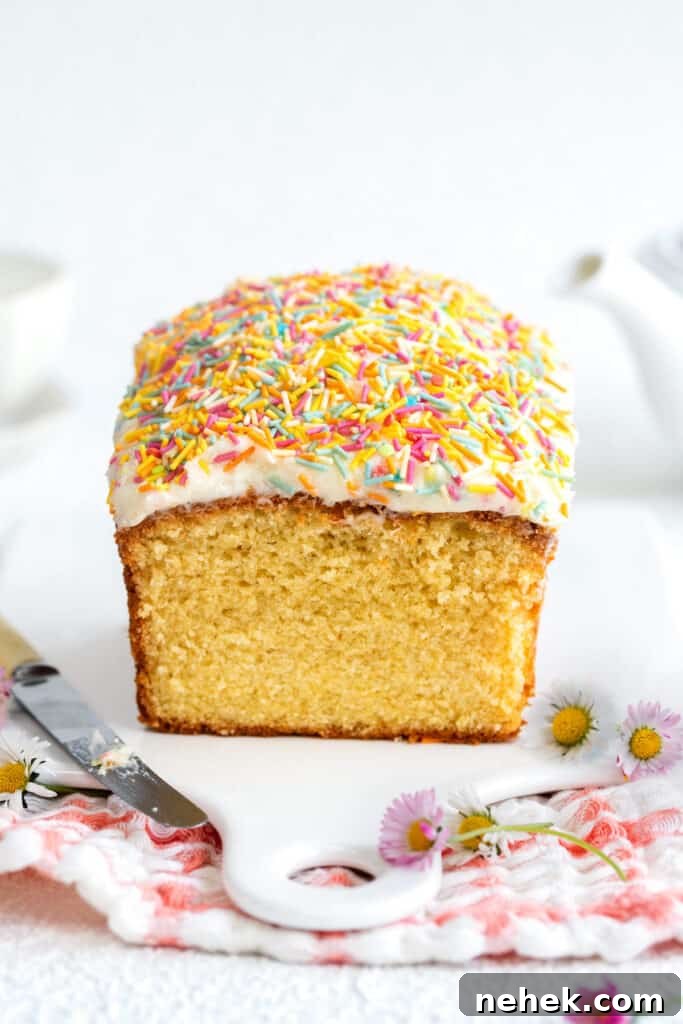 Classic Vanilla Loaf Cake Recipe with Moist, Tender Crumb 2 Sliced vanilla loaf cake topped with frosting and sprinkles