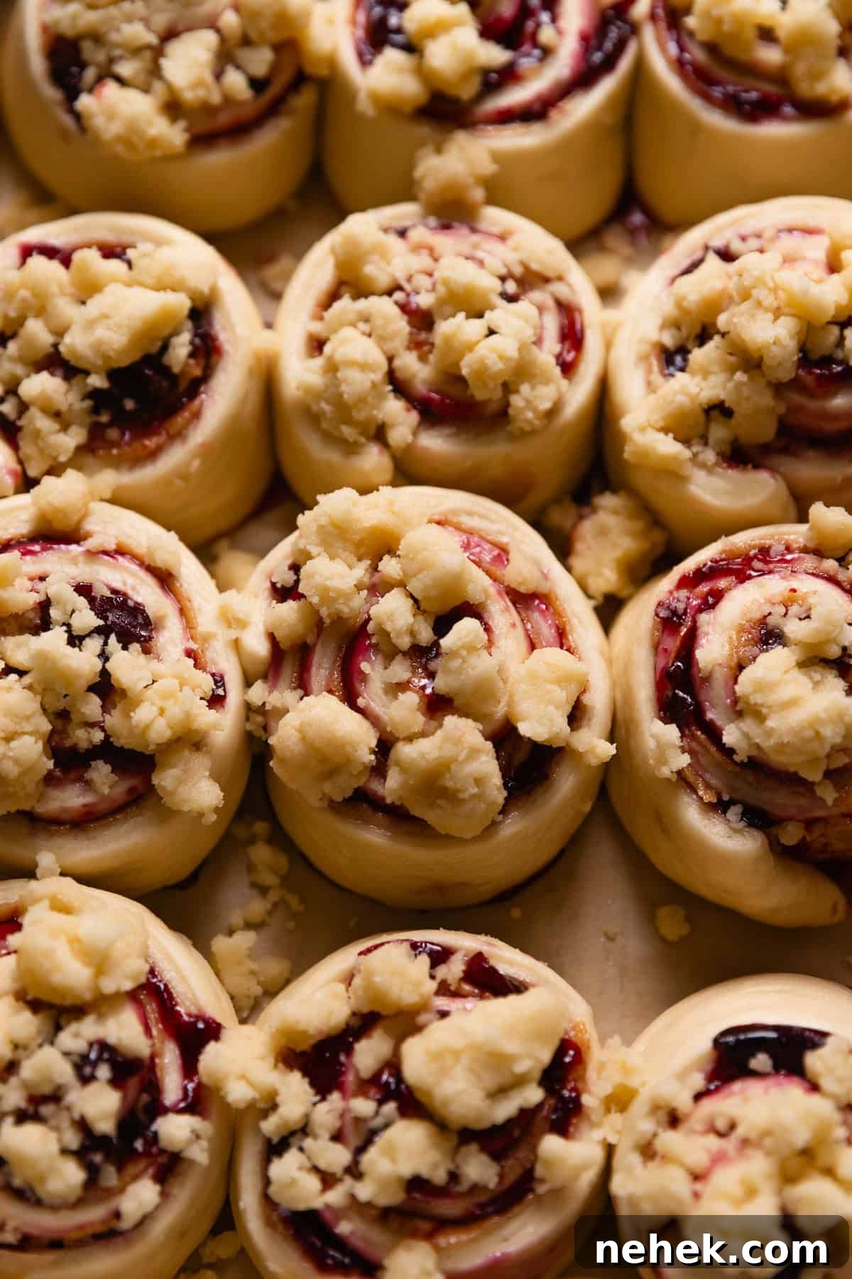 Cherry Pie Rolls with Crunchy Pie Crumb Topping 11 Unbaked cherry cinnamon rolls in a metal baking pan, topped with pie crumbs.