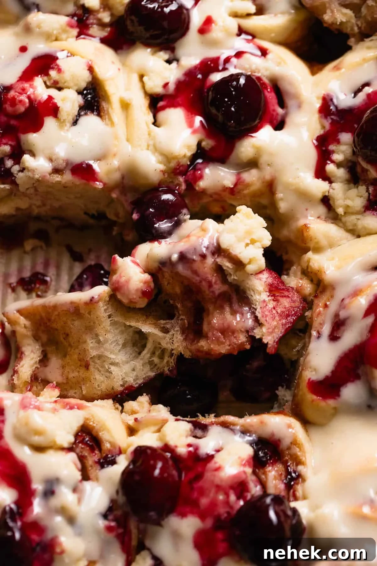 Cherry Pie Rolls with Crunchy Pie Crumb Topping 13 Overhead view of a cherry cinnamon roll being unrolled to show the gooey cherry filling.