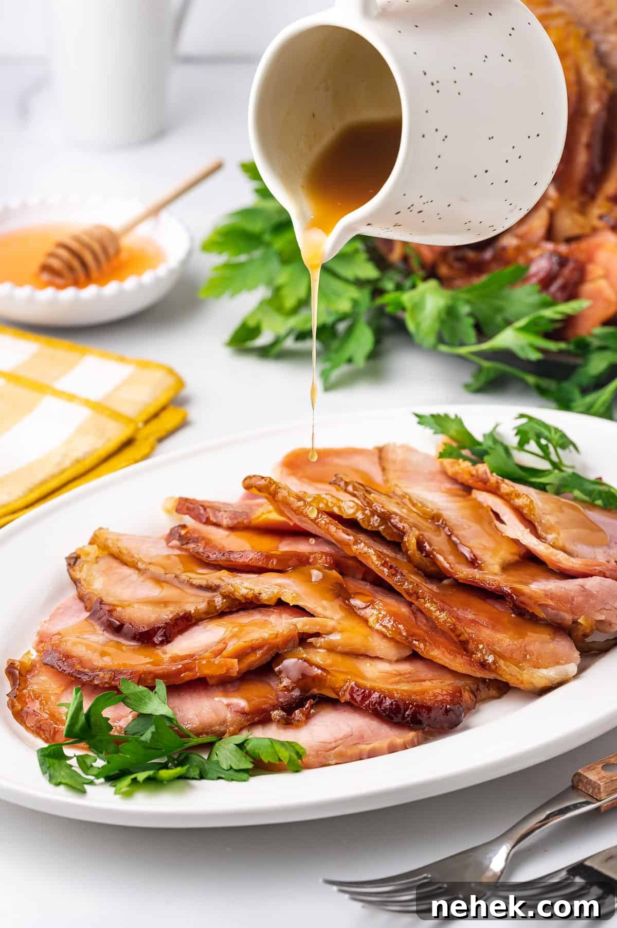 Slow Cooker Honey-Glazed Ham Recipe for Tender, Juicy Results 7 Sauce poured over sliced slow cooker ham on a platter.