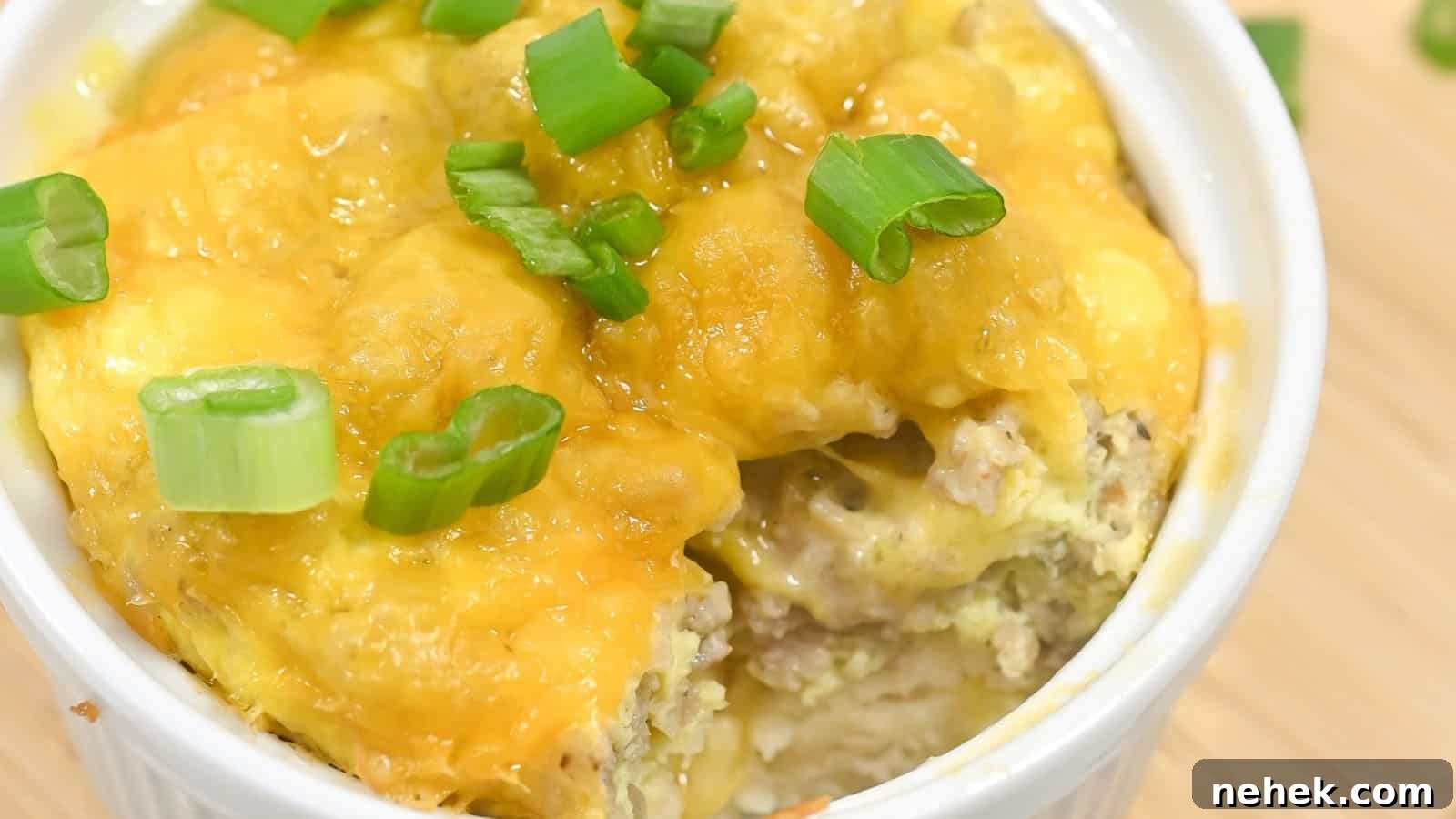 Steamed egg dish topped with melted cheese and garnished with chopped green onions, served in a white bowl.