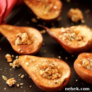 Maple Vanilla Baked Pears with Crunchy Granola Topping 11 Brown flexipan containing 6 baked pears topped with granola, red napkin around pan.