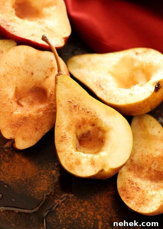 Maple Vanilla Baked Pears with Crunchy Granola Topping 7 Pear half topped with ground cinnamon sitting on a flexipan, maple syrup drizzled on top.